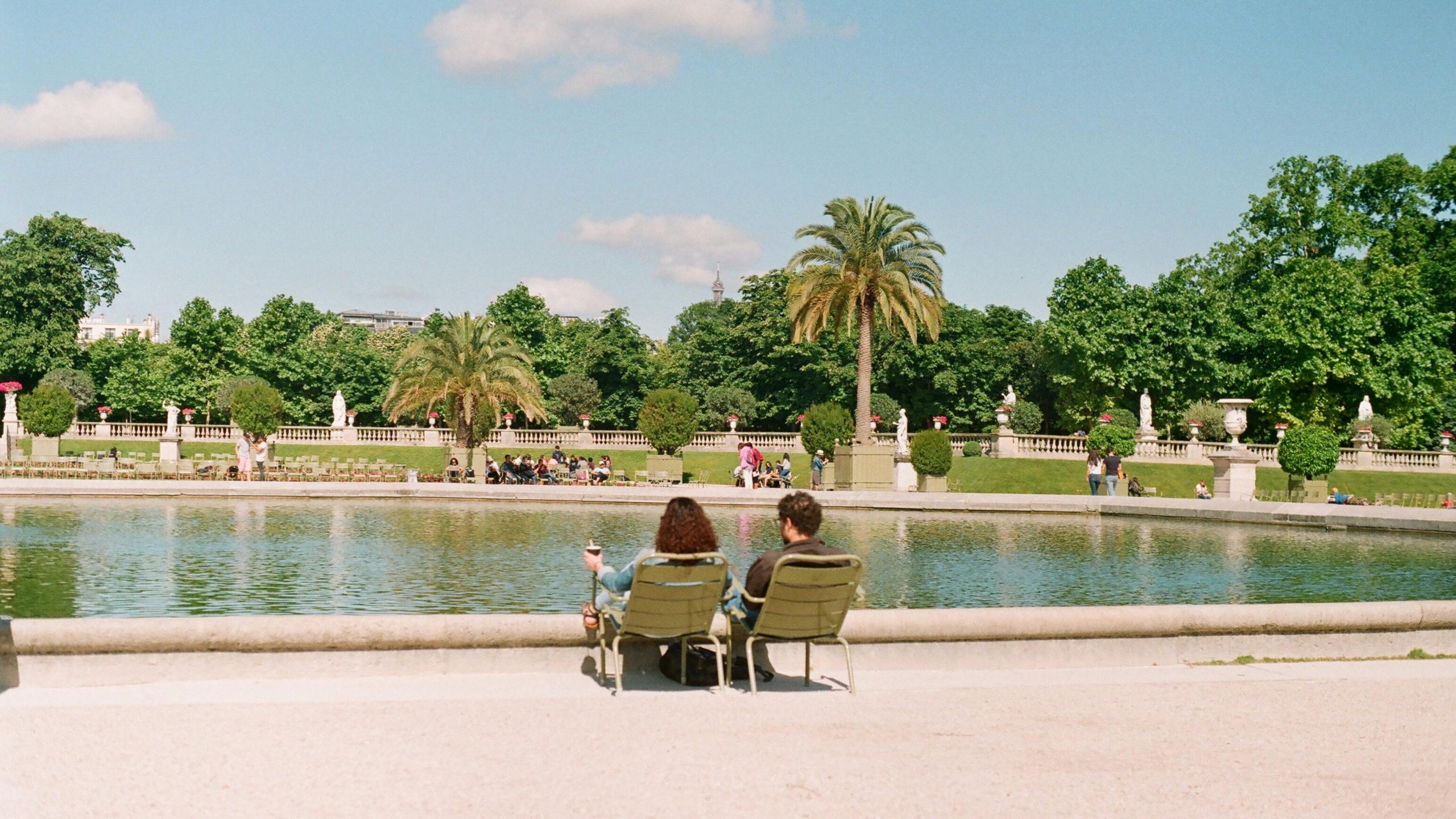 Couple sitting near pond of Luxembourg Gardens
